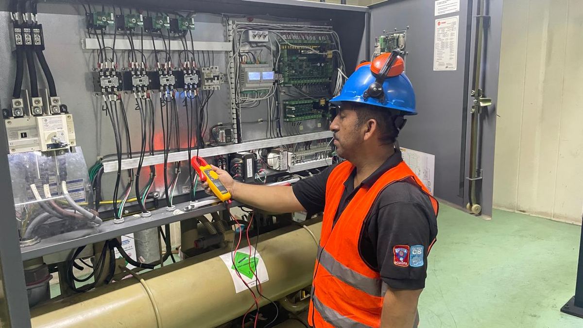 Técnico de Ecuclima revisando panel eléctrico con multímetro